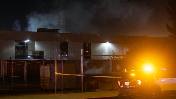 A Los Angeles Police officer stands guard near the scene after a news helicopter crashed in Chatsworth, a suburban neighborhood of Los Angeles, California on September 15, 2026.