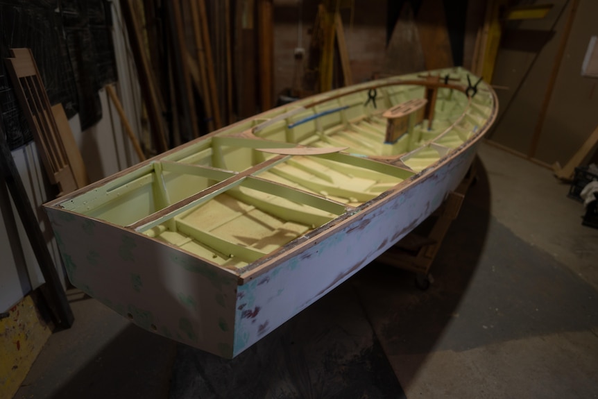 A boat being restored indoors.