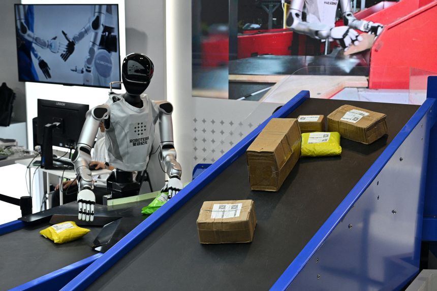 A humanoid robot is seen working with packages during the World Artificial Intelligence Conference in Shanghai, China on July 18, 2026.