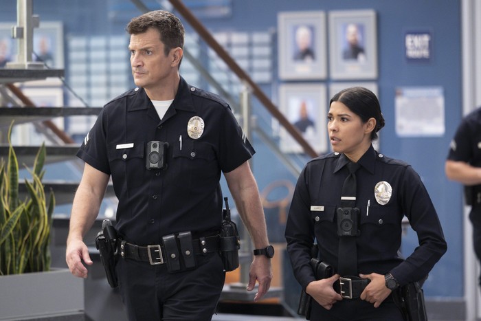 The Rookie - S6 Nathan Fillion and Alyssa Diaz in The Rookie, walking through the police station