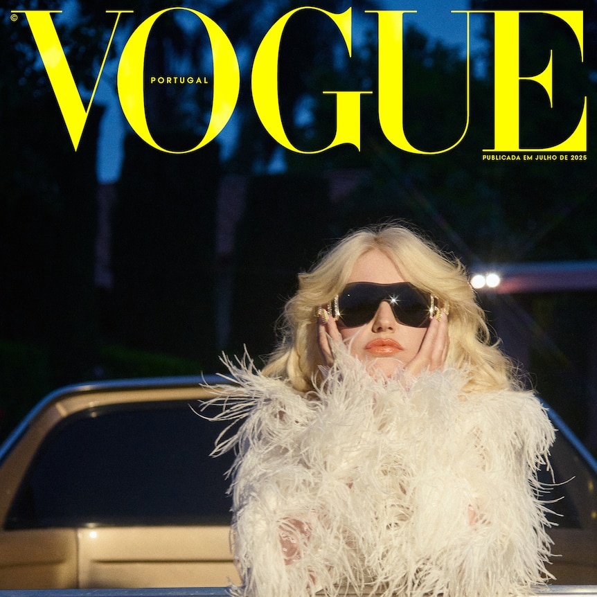 Amy Taylor on the cover of Vogue Portugal wearing a feathered top and dark sunnies, hanging out the back of a gold car.