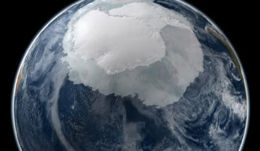 Microbes in Antarctica: About 3/4 of Earth globe with a large part of the upper area covered in white ice, surrounded by ocean and clouds.