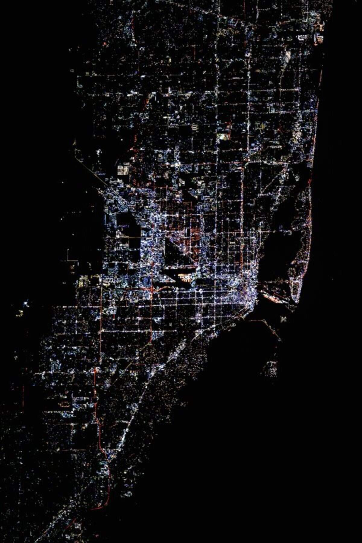 A photograph of Miami lit by multi-colored LEDs in 2025 taken from the International Space Station.