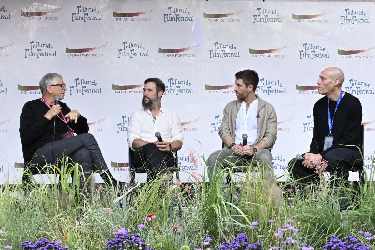 Panelists speak at an outdoor event.