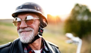 An older man wearing a helmet is set to ride his motorbike into the sunset, making the most of his retirement.