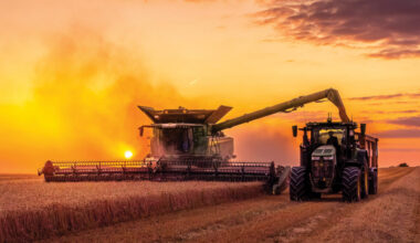 Scenic sunset photo of a John Deere X9 1100 combine working into the night