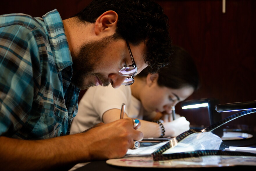 Elan Mendoza and Lena Mani draw on film at the Film Strip Club meeting at the Howson Branch Library.