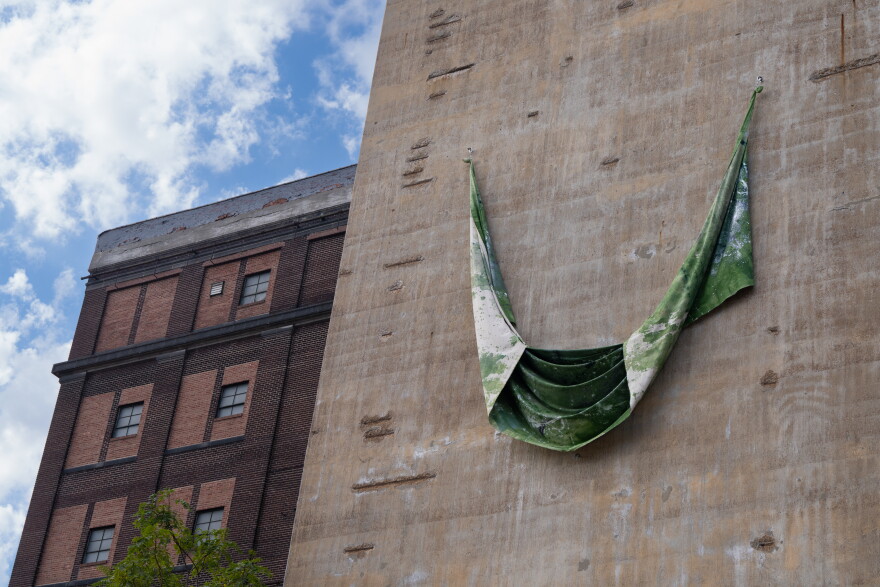 St. Louis-based artist Vaughn Davis, Jr.'s piece "Fields Green" is hung on the outside of a building that faces the Gateway Arch.