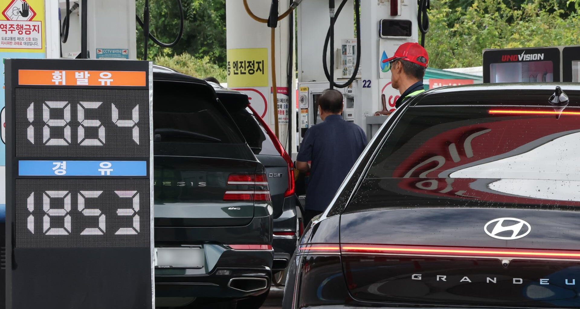 People refuel their cars at a gas station in Seoul, Sunday. Yonhap