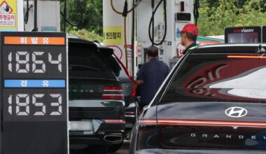 People refuel their cars at a gas station in Seoul, Sunday. Yonhap