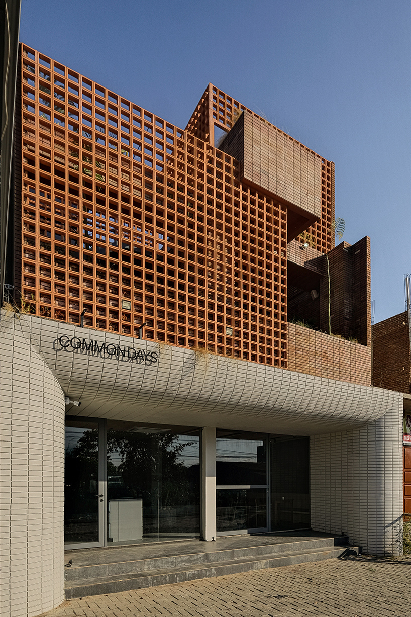 local stone, brick and terracotta screens layer across three-story gathering space in indonesia - 2
