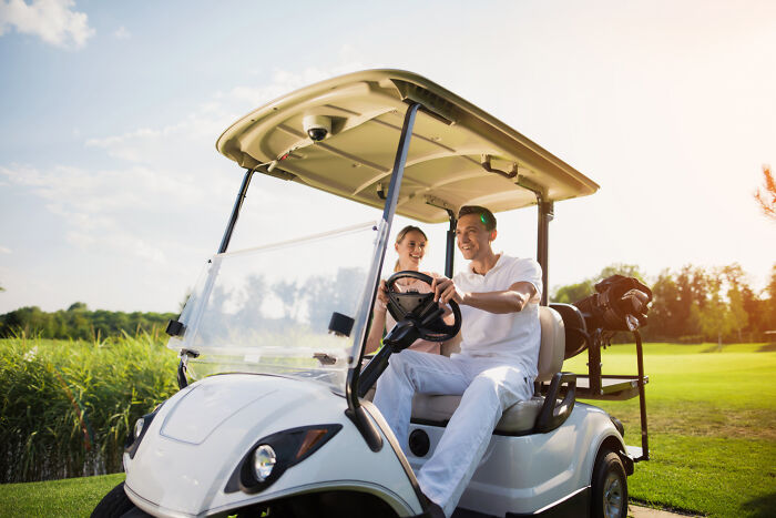 A couple enjoys a golf cart ride, illustrating serious issues medical professionals treated from innocent beginnings.