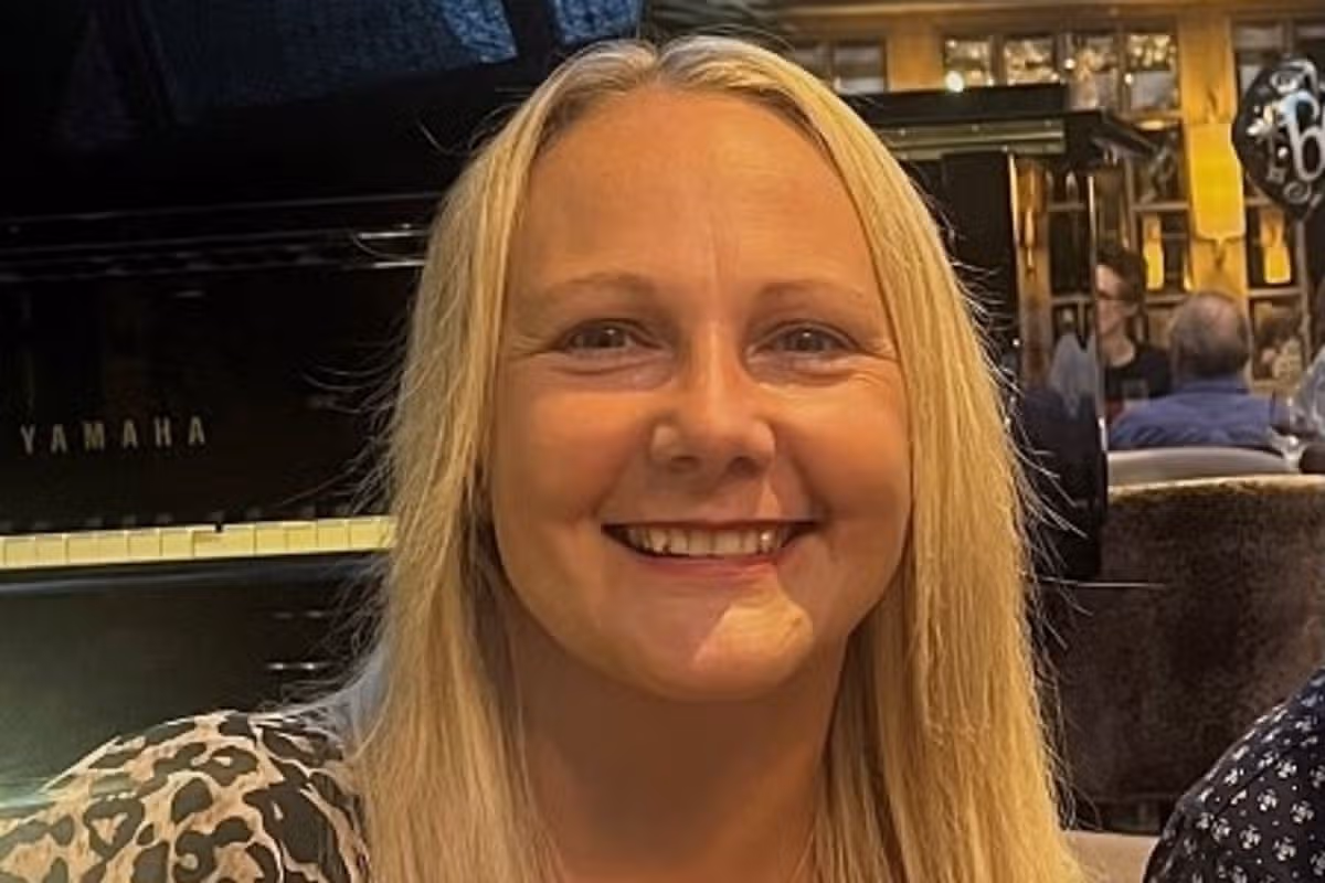 A smiling woman in her 40s with long blonde hair
