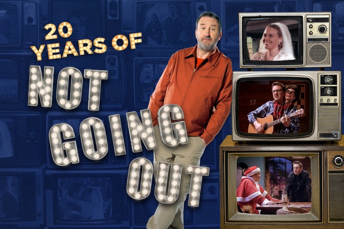 Lee Mack in a promo image for 20 Years of Not Going Out Lee Mack leaning on three TV screens stacked on top of each other showing classic scenes from Not Going Out, alongside big titles next to him, reading 20 Years of Not Going Out.