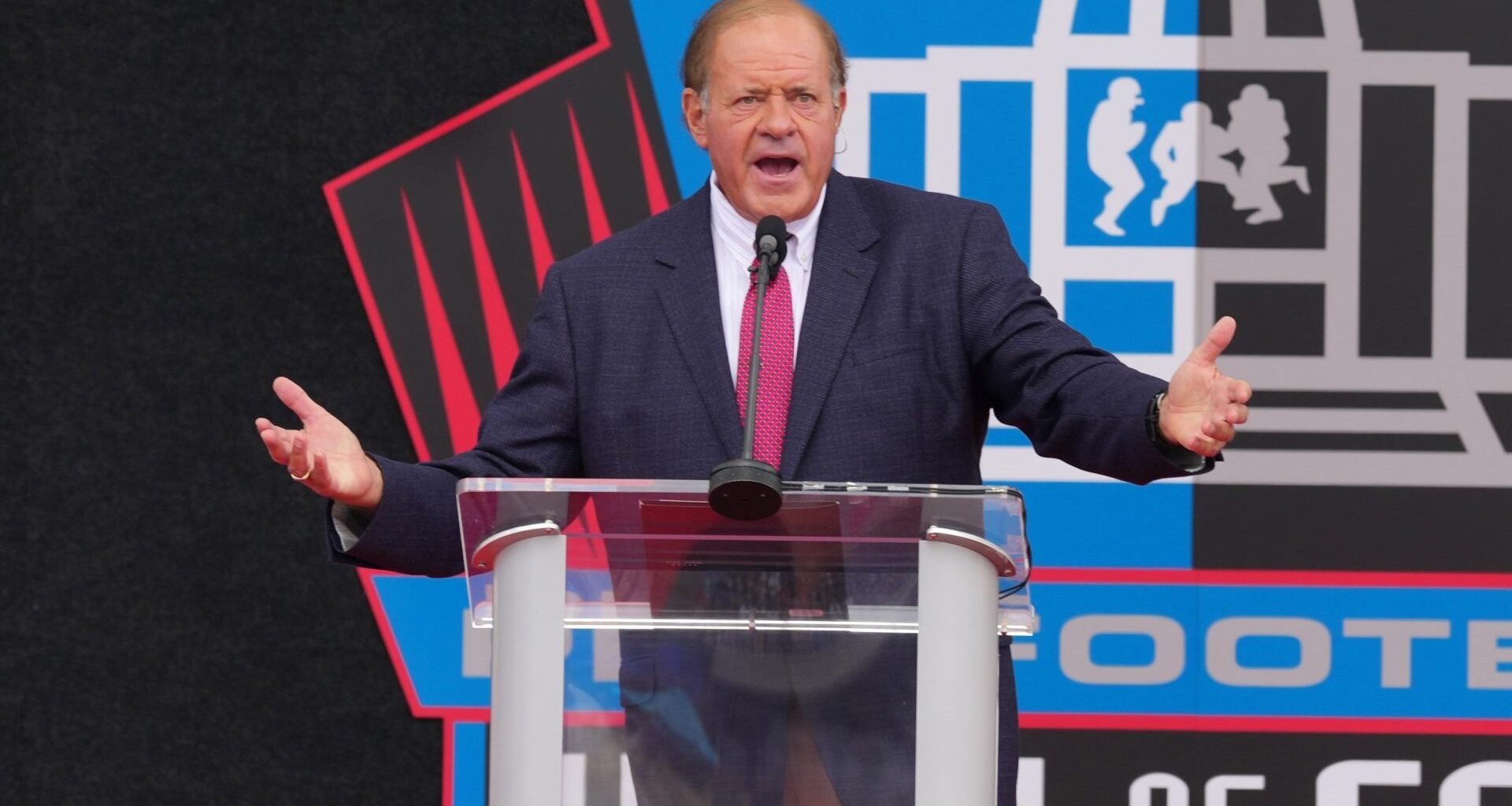 Aug 8, 2026; Canton, OH, USA; Chris Berman moderates the Pro Football Hall of Fame enshrinement at Tom Benson Hall of Fame Stadium. Mandatory Credit: Kirby Lee-Imagn Images