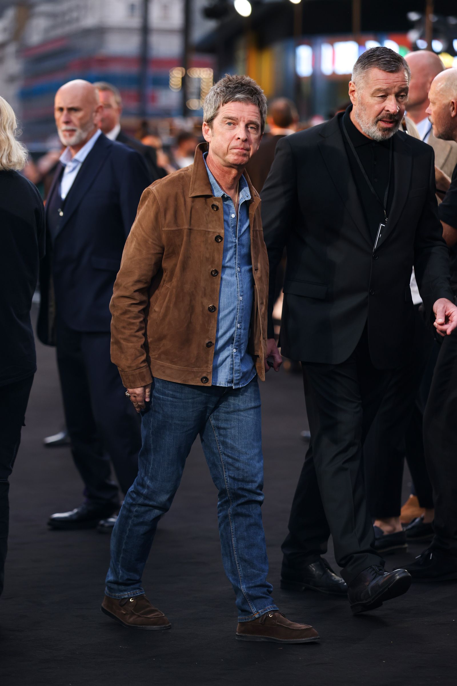 Image may contain Noel Gallagher Clothing Coat Pants Jacket Adult Person Blazer Jeans Footwear Shoe and Walking