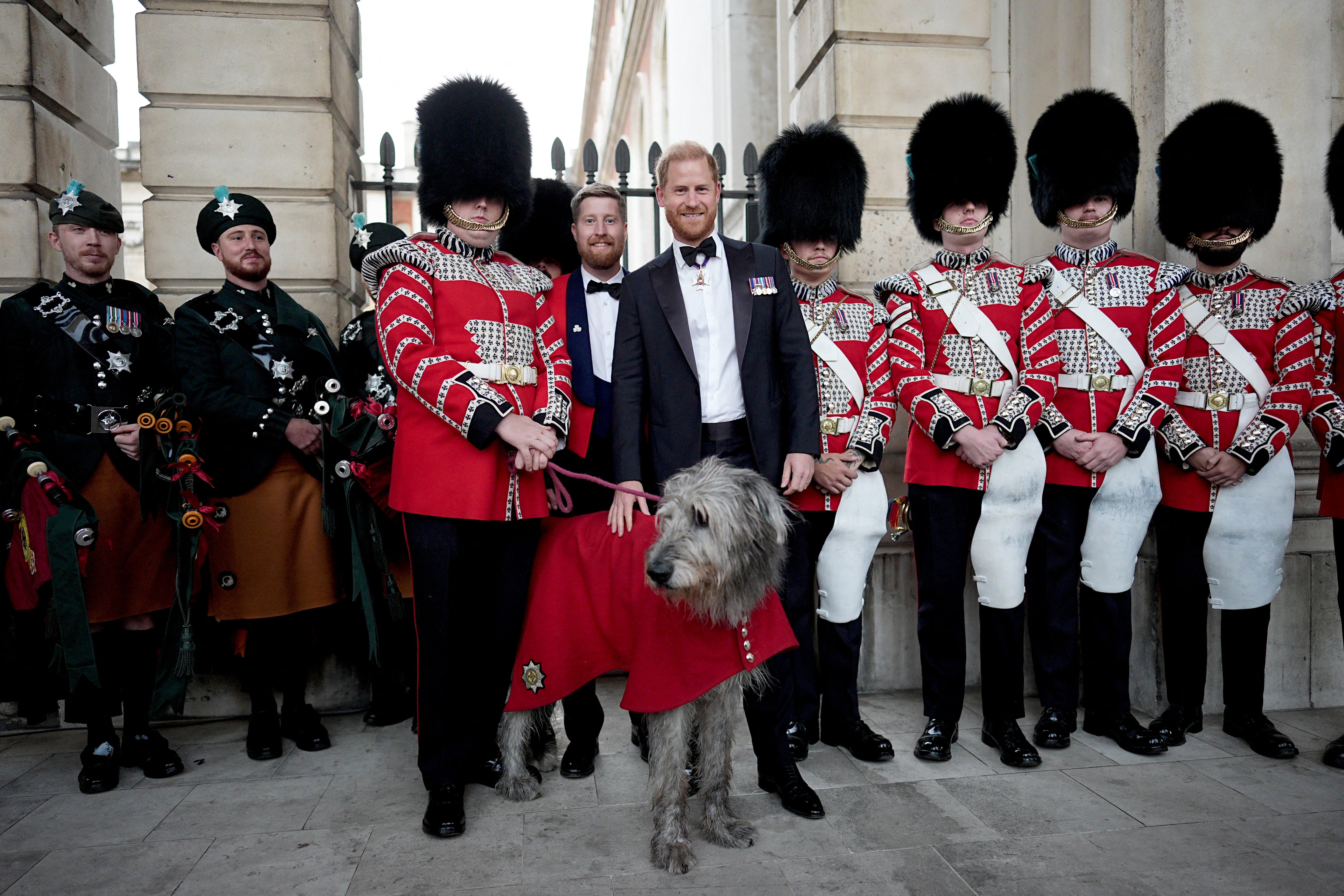 Britain's Prince Harry, Duke of Sussex poses with members of the Band of the Irish Guards and their mascot, Irish wolfhound dog 'Seamus'