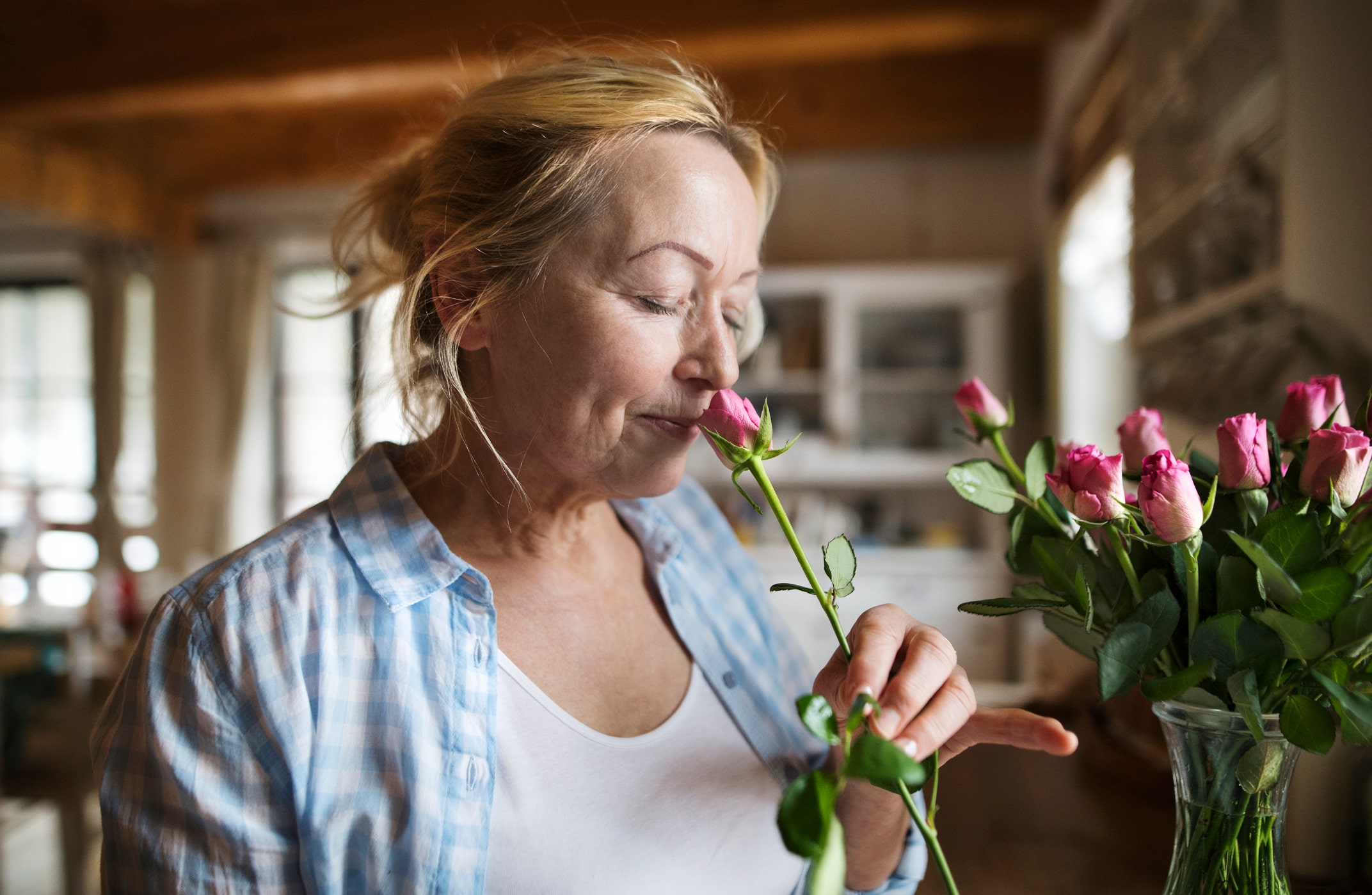 woman at home smelling flower