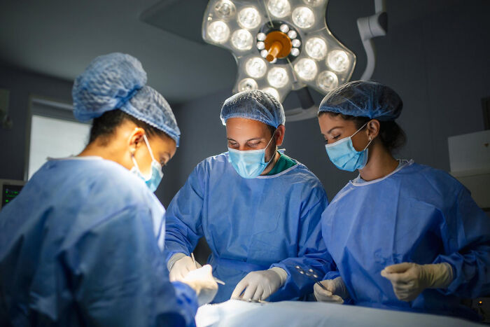 Doctors performing a standard medical procedure in an operating room, highlighting medical procedures.