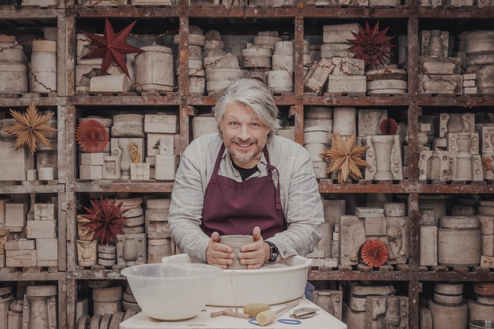 Richard Herring sat down at a potting station smiling as he looks up.