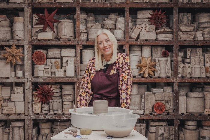 Denise Van Outen sat back at a potting station smiling ahead.