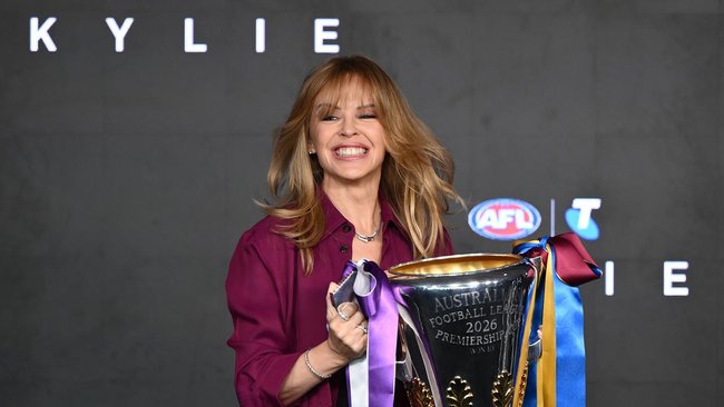 Superstar Kylie Minogue holds the premiership cup before finally performing at an AFL grand final.  