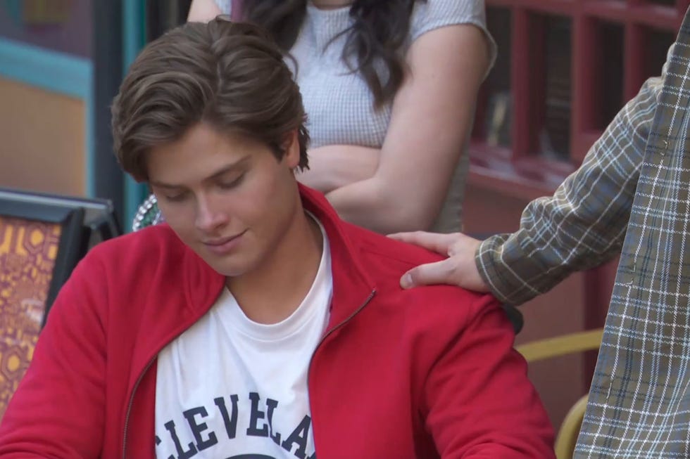 Hollyoaks Caleb Keane hollyoaks caleb keane in a red jacket being comforted by jonah's hand on his shoulder