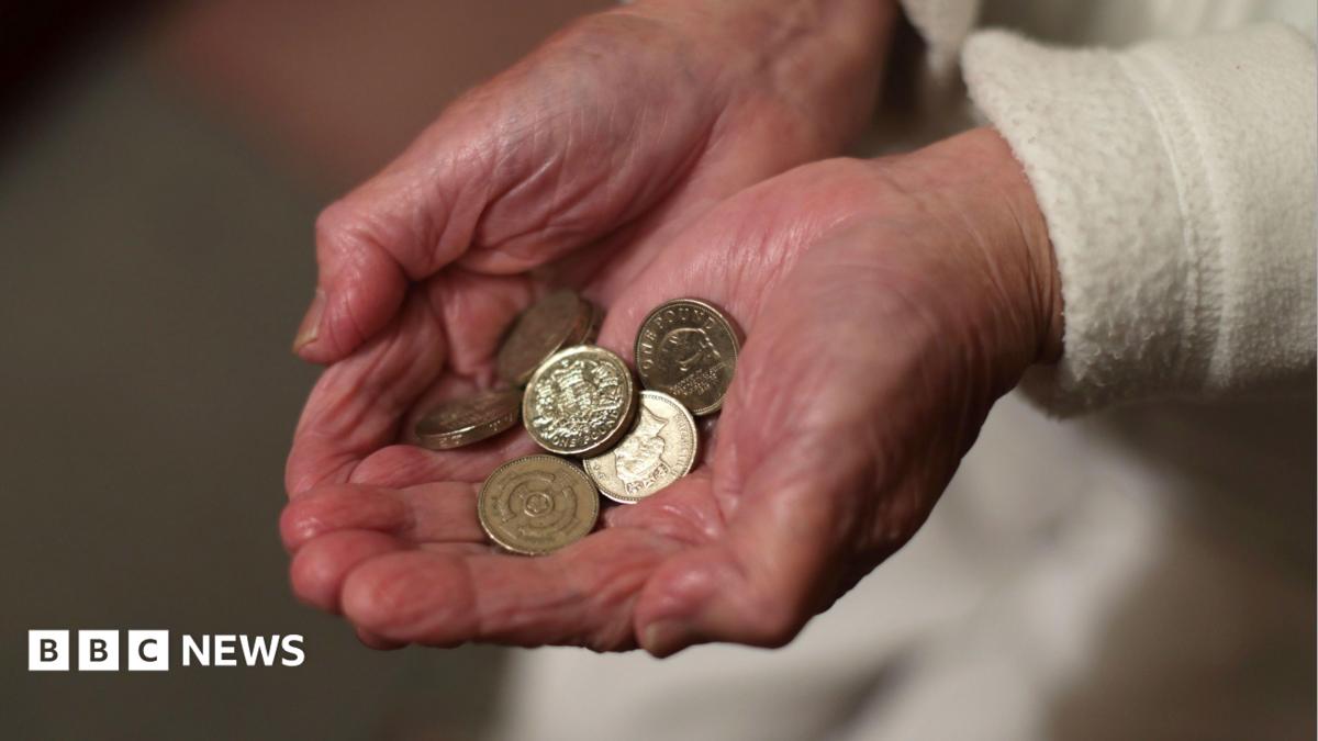 Close up of elderly person with wrinkled hands holding pound coins