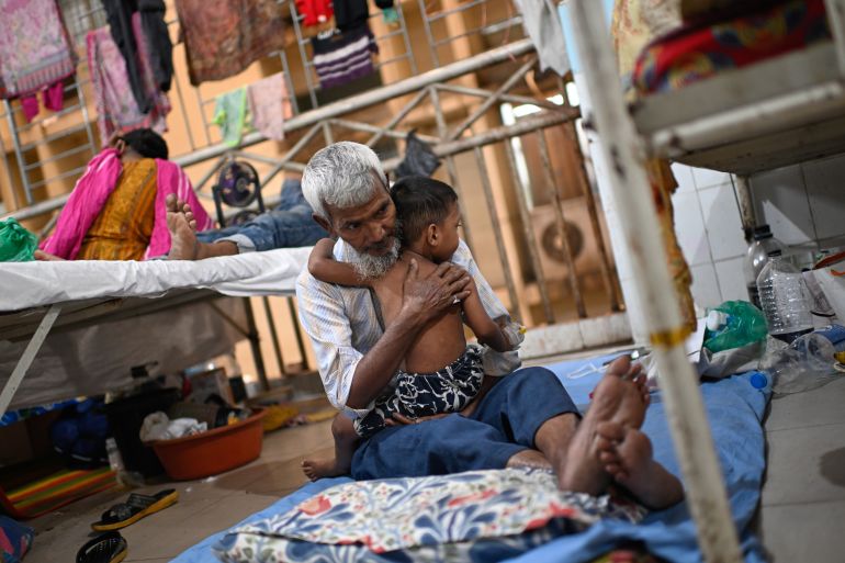 A person takes care of his grandchild while getting treatment of measles outbreak in a hospital in Dhaka, Bangladesh, Tuesday, Sept. 8, 2026. (AP Photo/Mahmud Hossain Opu)