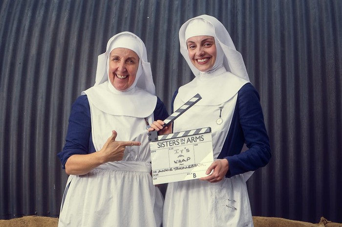 Julie Hesmondhalgh as Sister Alice and Helena Wilson as Sister Julienne in Call the Midwife: Sisters in Arms., holding a clapperboard.