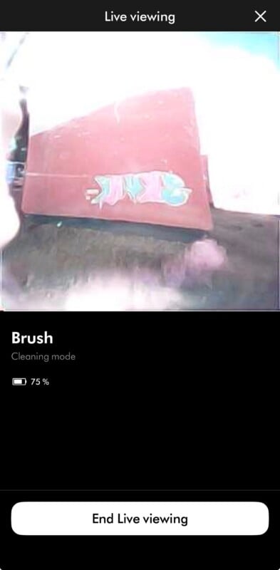 A smartphone screen displays a live camera feed of a red surface with graffiti, labeled as "Brush" in "Cleaning mode" with a 75% battery indicator.
