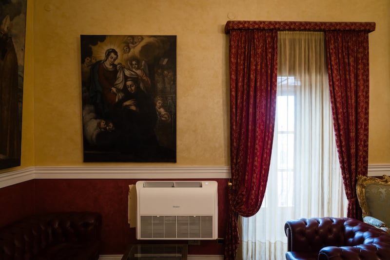 An air-conditioning unit underneath a religious painting in the office of Michele Sodano, the mayor of Agrigento, Italy. Photograph: Gianni Cipriano/The New York Times
                      