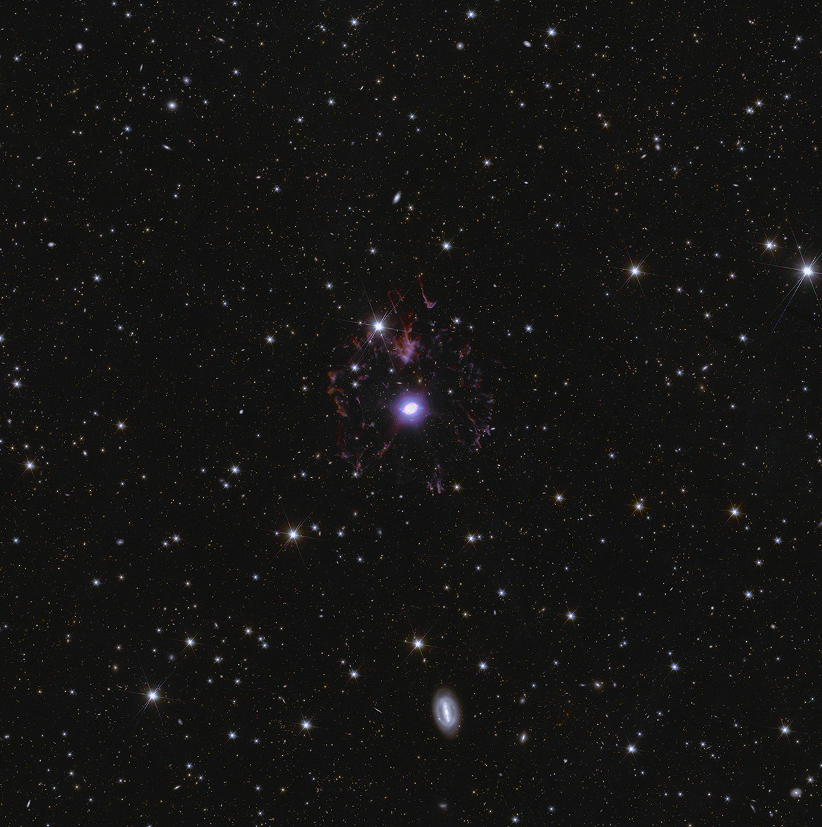 A zoom-in of Euclid’s Deep Field North image, showing the Cat’s Eye Nebula in the centre. This is a 'planetary nebula', the final stages of a dying star shedding its outer layers into space. Credit: ESA/Euclid/Euclid Consortium/NASA, image processing by J.-C. Cuillandre, E. Bertin, G. Anselmi