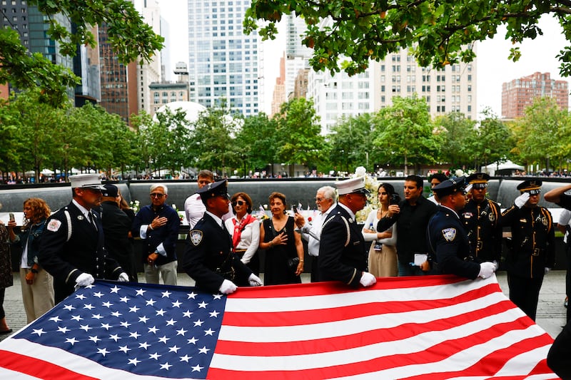 Law enforcement officers carry an American flag during the 25th anniversary commemoration ceremony at the National 9/11 Memorial and Museum in New York, US, on Friday, September 11th 2026. Photographer: Jeenah Moon/Reuters/Bloomberg