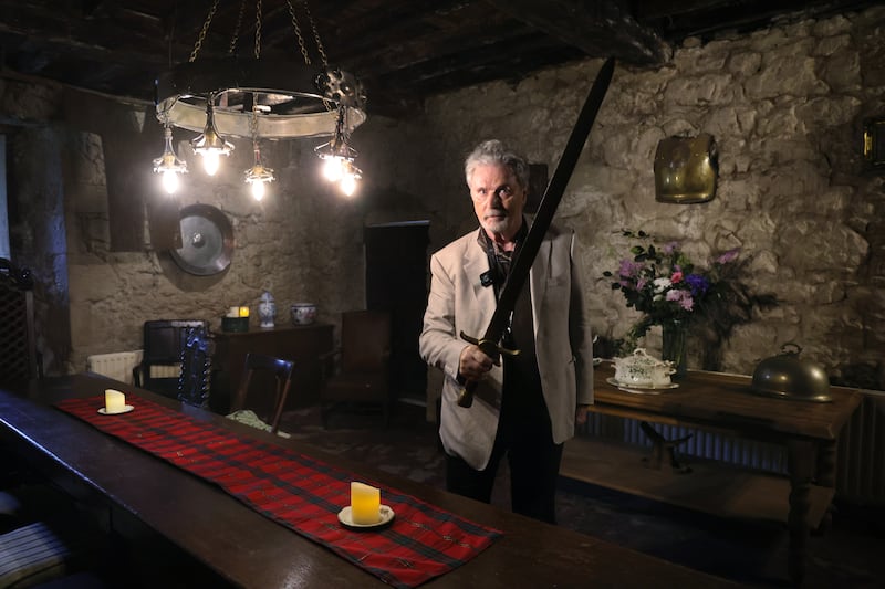 Patrick Bergin holds the sword from his movie Robin Hood in the guard room. Photograph: Bryan O’Brien