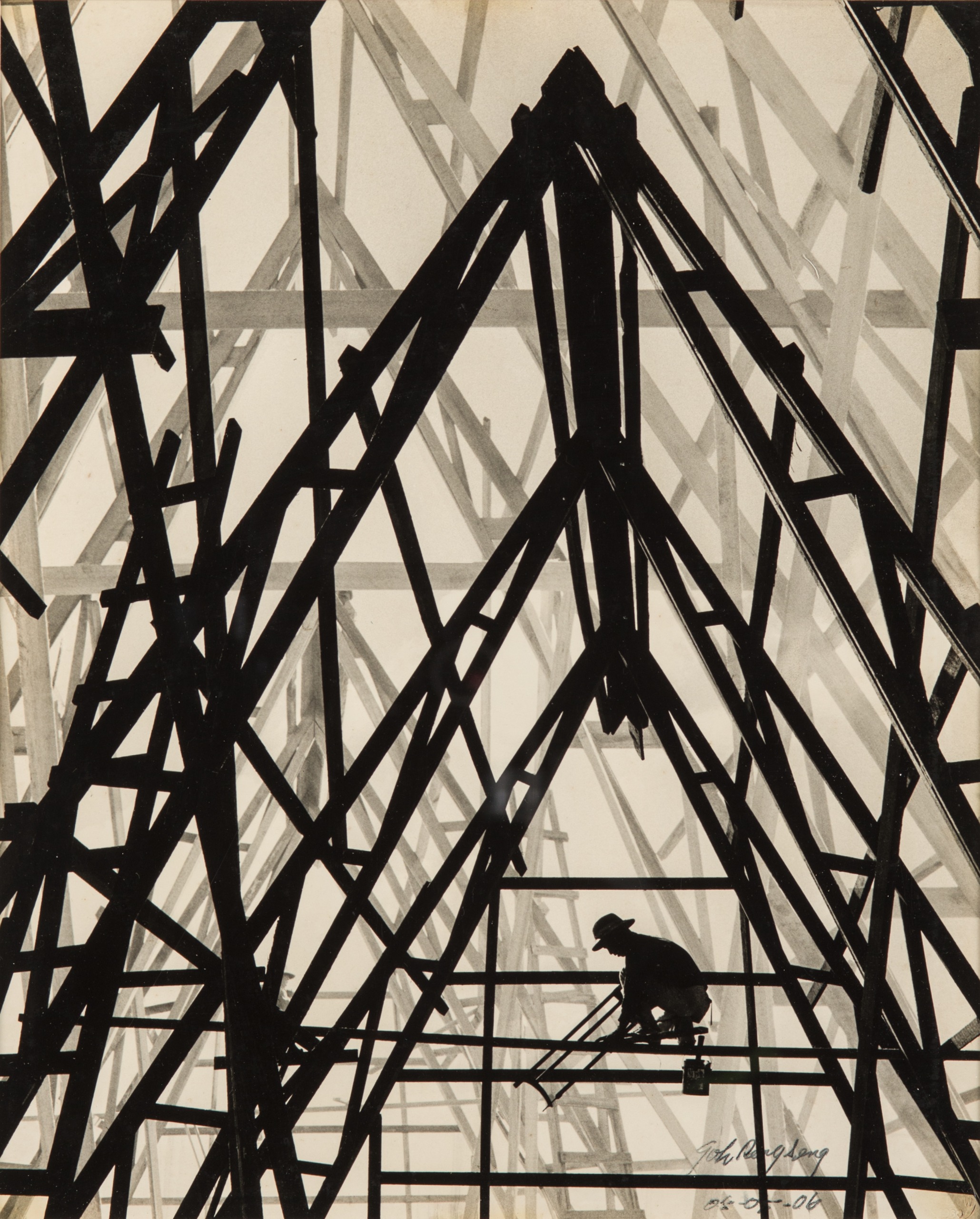 A silhouetted worker crouches within the dramatic criss-crossing timber trusses of a building's roof structure, photographed from below.