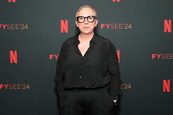 GettyImages-2153252720 Abi Morgan stood in front of a black backdrop with Netflix logos