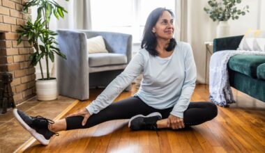 Woman stretching hamstrings on wooden floor at home to set up for Romanian deadlift exercise