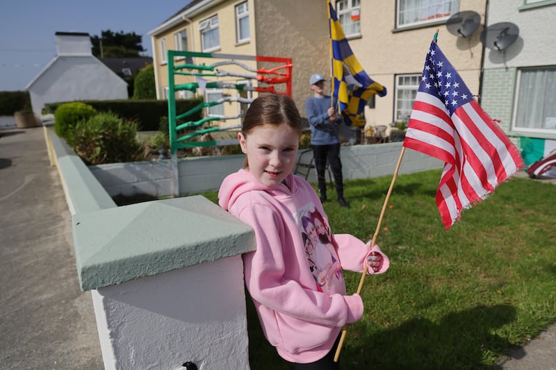 Mia McInerney (6) holds the stars and stripes as her brother James  (13) holds the Clare flag in Doonbeg village. Photo: Bryan O’Brien / The Irish Times 