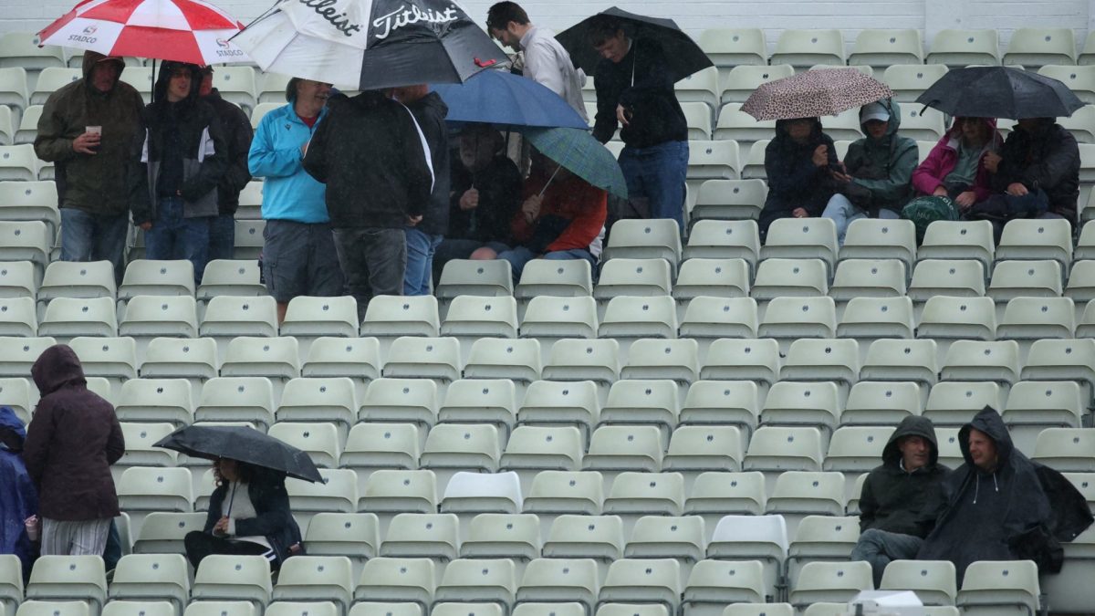 Cricket - Third Test - England v Pakistan - Edgbaston Cricket Ground, Birmingham, Britain - September 10, 2026 Fans in the stands hold umbrellas as the match is delayed by rain Action Images via Reuters/Andrew Boyers