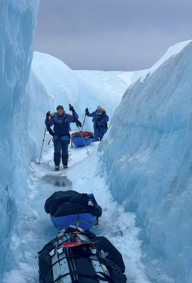 Two people pulling sleds in Greenland.