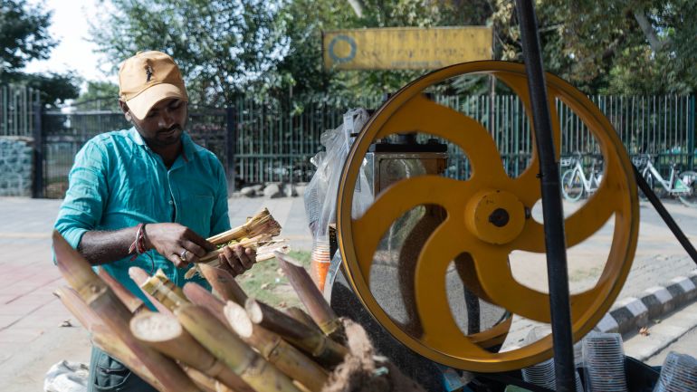 A local vendor extracts juice from sugarcane. Sugarcane production in India has come under pressure as some farmers switch to other crops because of low returns, reduced rainfall during El Niño weather conditions and diseases such as red rot. (Picture by Wasim Nabi for Al Jazeera)