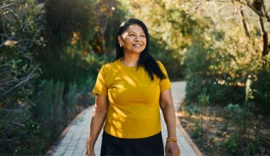 Woman walking along path in sunshine