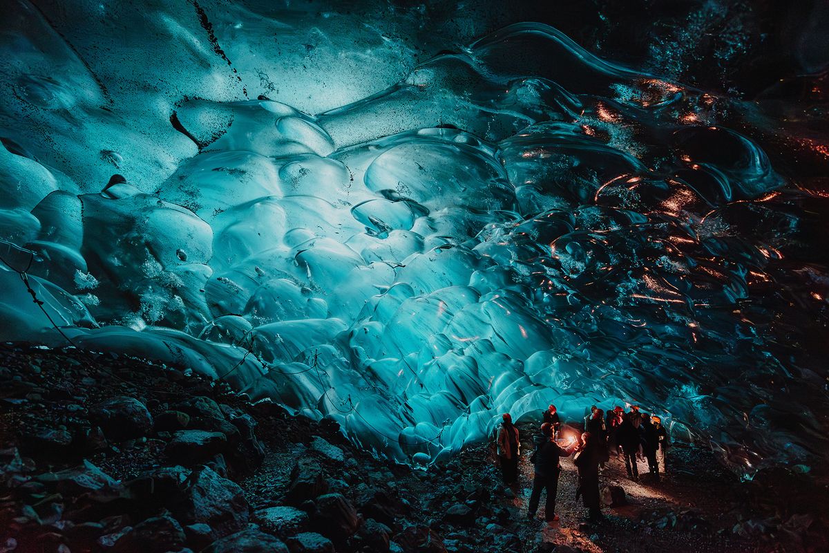 Photograph taken at the Amazon Influencer Program in Iceland for the BRYANT brand, by Luke Dyson. It shows guests exploring a glacier cave illuminated from within.