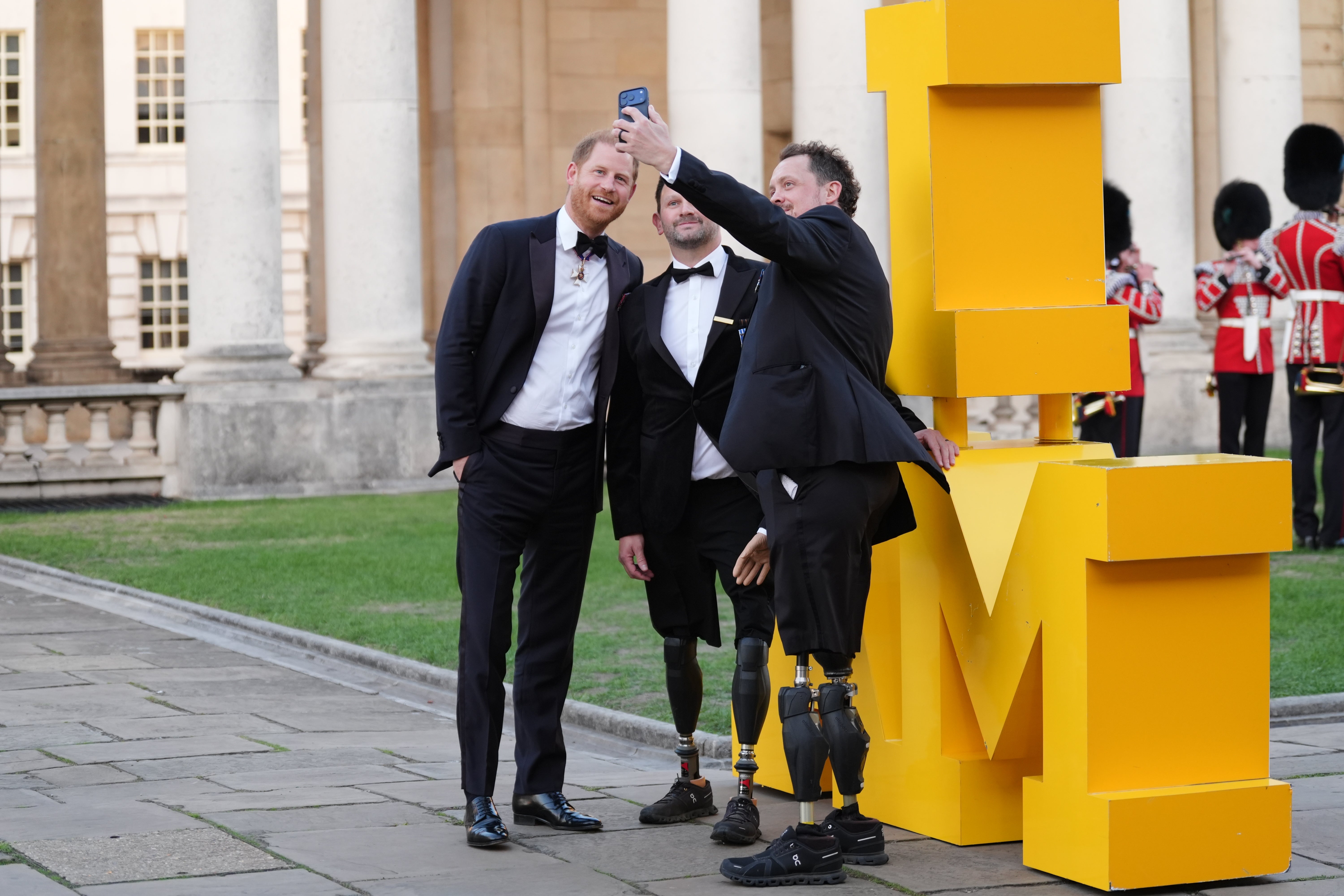 The Duke of Sussex has a selfie taken with Steve Arnold (centre) and Josh Boggi, as he arrives at the inaugural Invictus Spirit Awards