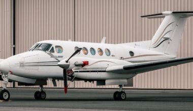 A two-engine aircraft sitting in front of a hangar.