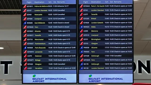 The board at Belfast International Airport shows cancellations as well as other flights taking off normally