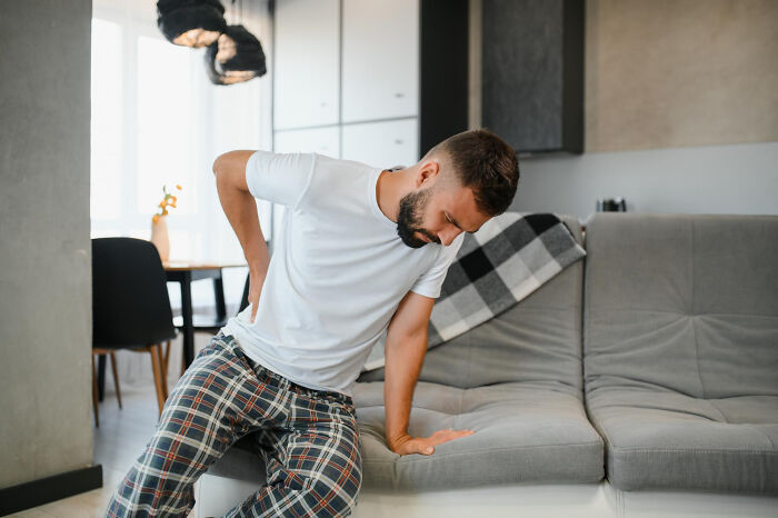 Man experiencing back pain, illustrating how a seemingly innocent ache can become a serious medical issue.