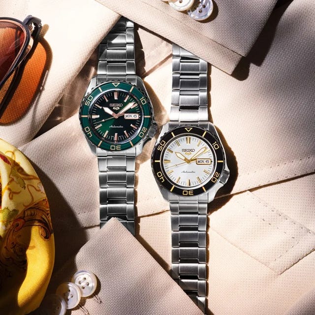 two seiko automatic watches with metal bands on beige fabric background. two seiko automatic watches with metal bands on beige fabric background.