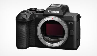 A black Canon EOS R8 Mark II mirrorless camera body shown from the front, featuring a lens mount, a textured grip, and a mode dial on top.